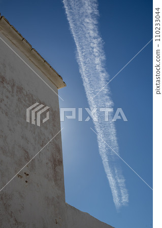 Typical white archtecture and blue sky with chemtrails 110233044