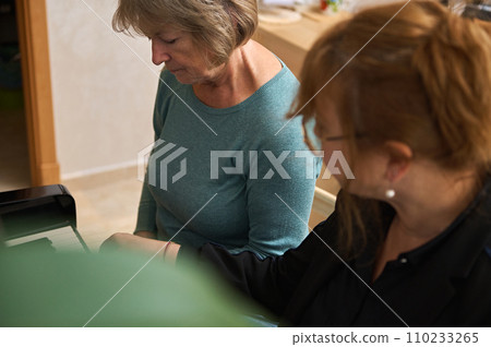 Pretty women musicians engrossed in a music studio lesson, harmonizing melodies on acoustic piano while singing together 110233265