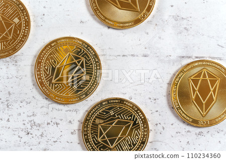 Top down view, golden commemorative EOS - EOSIO  cryptocurrency - coins on white stone board 110234360