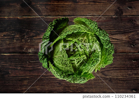 Top down view, savoy cole cabbage on dark wooden board 110234361