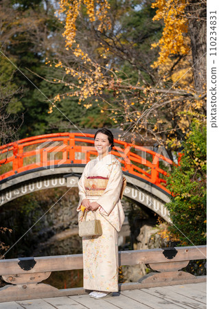 一位穿著和服的女人站在日本花園的橋上 一位穿著和服的女人站在日本花園的橋上 110234831