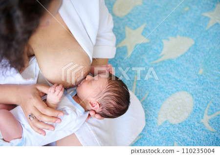 Mother breastfeeding her newborn baby. Mother breast milk is the best medicine for kids the first six months of life Mother breastfeeding her newborn baby. Mother breast milk is the best medicine for kids the first six months of life 110235004
