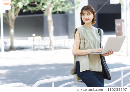 一名女大學生在新綠色中使用筆記本電腦 110235597