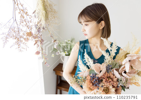 One-piece woman holding a bouquet of dried flowers 110235791