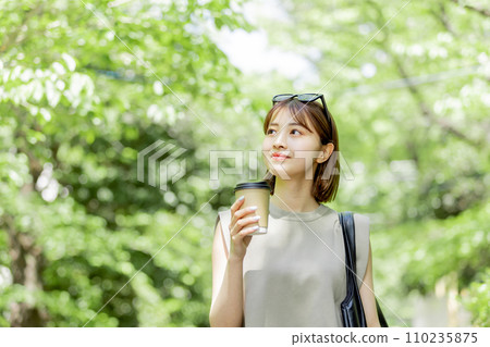 Young woman drinking coffee in fresh green 110235875