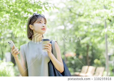A female college student using a smartphone in the fresh green 110235918