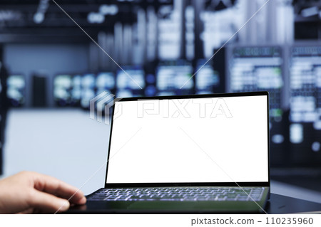 Close up shot of mock up laptop used by trained engineer in data center using server rows to deliver massive computing power, control network resources, process and store datasets 110235960