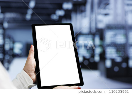 Close up shot of mock up tablet used by IT programmer in data center delivering massive computing power, capable of processing and storing vast amounts of datasets and controlling network resources Close up shot of mock up tablet used by IT programmer in data center delivering massive computing power, capable of processing and storing vast amounts of datasets and controlling network resources 110235961