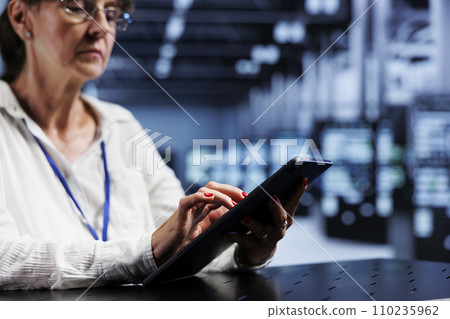 Aged technical support consultant using tablet to assess server security glitches arising due to unsecured network connections. Certified expert ensuring data center is impenetrable by virus attacks Aged technical support consultant using tablet to assess server security glitches arising due to unsecured network connections. Certified expert ensuring data center is impenetrable by virus attacks 110235962