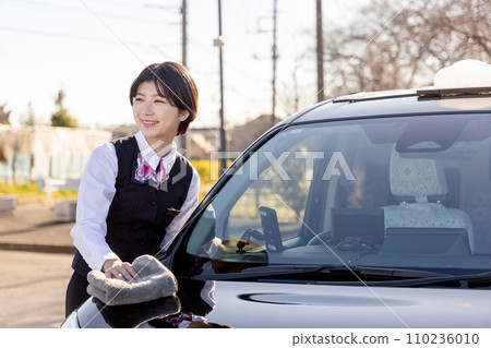 Female driver polishing a taxi Female driver polishing a taxi 110236010