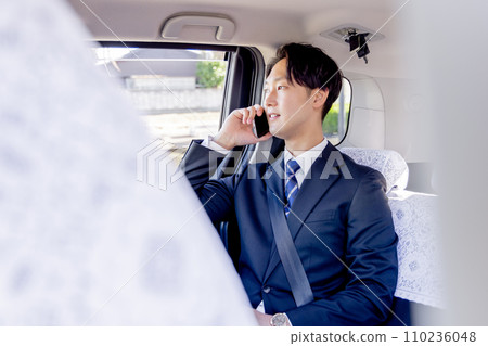 坐在計程車後座上用智慧型手機交談的商人 110236048