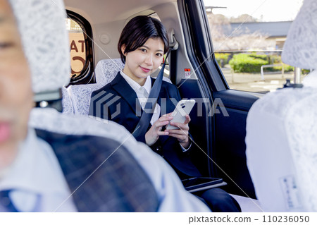 在計程車後座使用智慧型手機的女商人 110236050