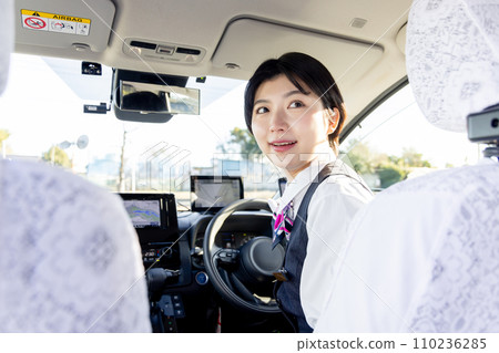 A female taxi driver checking the rear view 110236285