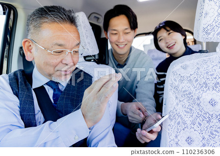 一對夫婦在旅行時展示他們的智慧型手機並告訴他們乘坐出租車的目的地 一對夫婦在旅行時展示他們的智慧型手機並告訴他們乘坐出租車的目的地 110236306