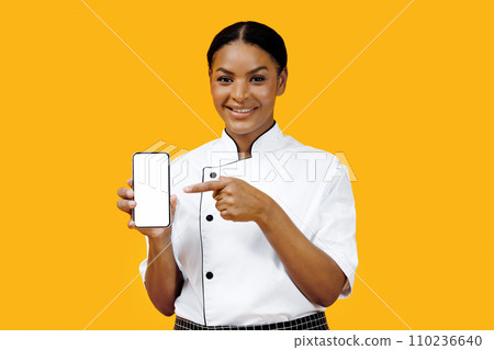 Cooking App. Black Female Chef Pointing At Blank Smartphone In Her Hand Cooking App. Black Female Chef Pointing At Blank Smartphone In Her Hand 110236640