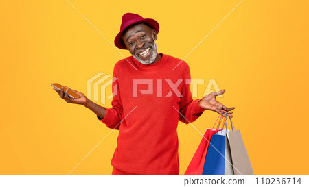 Smiling confused old black man shopaholic in hat, shrugs shoulders with many bags Smiling confused old black man shopaholic in hat, shrugs shoulders with many bags 110236714