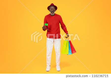 Glad surprised senior african american man shopaholic in hat with open mouth and many bags with purchases Glad surprised senior african american man shopaholic in hat with open mouth and many bags with purchases 110236715