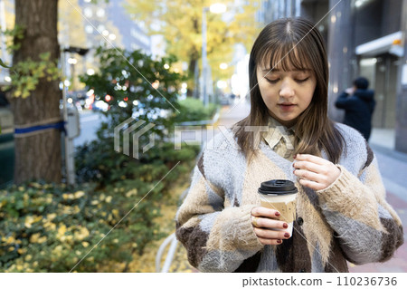 A woman with hot coffee outdoors 110236736