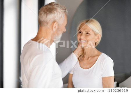 Romantic elderly couple sharing tender moment in bathroom Romantic elderly couple sharing tender moment in bathroom 110236919