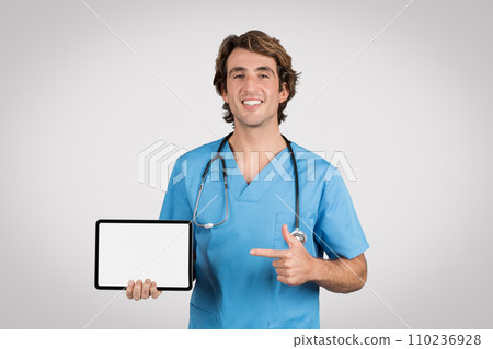 Confident male nurse presenting tablet with blank screen 110236928