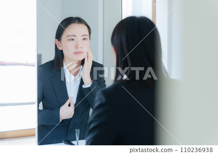 A young business woman worried about beauty A young business woman worried about beauty 110236938