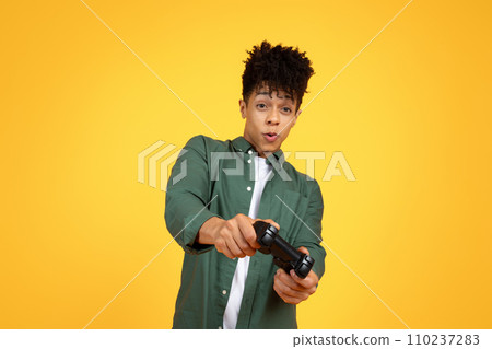 Cool african american guy holding joystick, playing video game 110237283