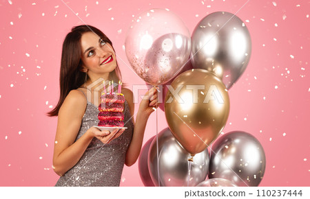 A beaming woman with dark hair, wearing a sequin silver dress 110237444
