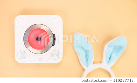 White cd player with red disc with bunny ears on yellow background. Love music, Easter bunny, retro Love song, space for text. White cd player with red disc with bunny ears on yellow background. Love music, Easter bunny, retro Love song, space for text. 110237712