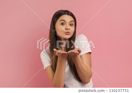 Charming teen girl blowing a playful kiss at camera, hands extended forward 110237731