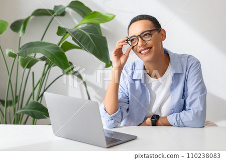 Positive millennial latin lady in glasses at table with computer, enjoy work and study Positive millennial latin lady in glasses at table with computer, enjoy work and study 110238083