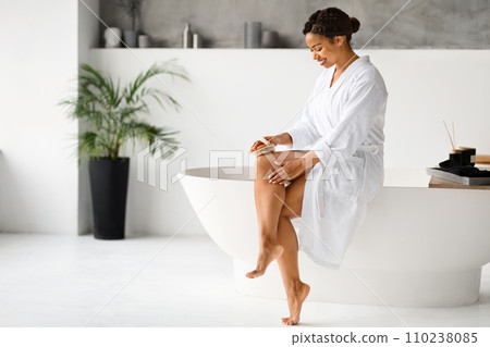 Happy Young African American Woman Dry Brushing Legs In Bathroom 110238085