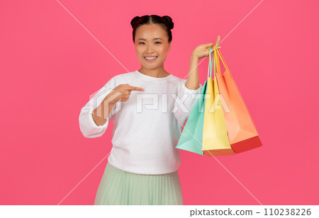 Shopping Sales. Smiling Asian Woman Pointing At Paper Shopper Bags In Hand 110238226