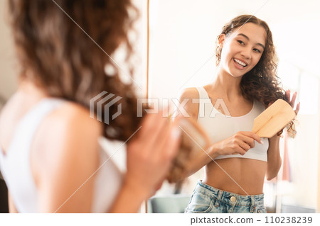 Happy Teen Girl Brushing Hair With Wooden Hairbrush At Home Happy Teen Girl Brushing Hair With Wooden Hairbrush At Home 110238239
