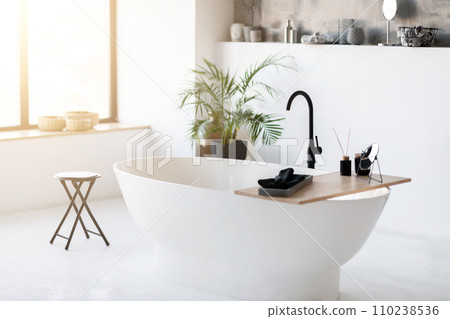 Spacious, modern bathroom interior featuring sleek freestanding bathtub Spacious, modern bathroom interior featuring sleek freestanding bathtub 110238536