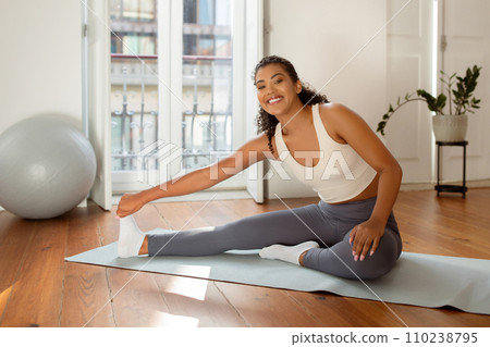 Young fit lady making stretching exercises at home Young fit lady making stretching exercises at home 110238795