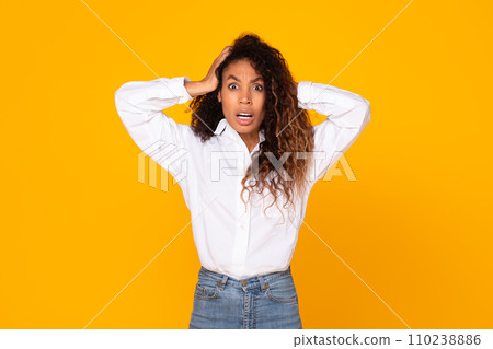 Shocked young black woman touching head looking at camera, studio Shocked young black woman touching head looking at camera, studio 110238886
