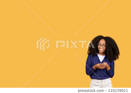 Cheerful black lady in casual using smartphone, looking at copy space for mobile application advertisement, banner 110239021