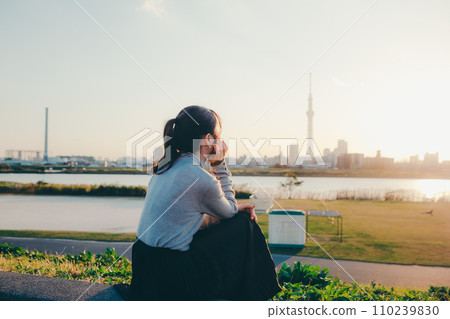 Female college student standing at dusk Female college student standing at dusk 110239830