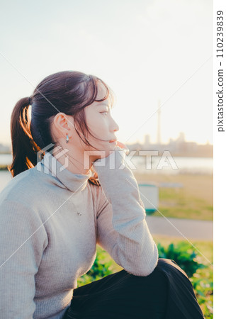 Female college student standing at dusk Female college student standing at dusk 110239839