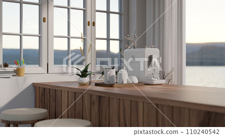 A modern coffee maker machine and a mug tray on a wooden counter bar near by a window with stools 110240542