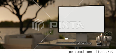 A computer mockup on a desk with a blurred background of a beautiful lounge terrace with sunset view 110240549