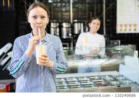 Woman drinks tonic bubble tea through straw 110240686