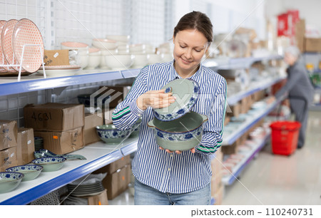 Woman customer chooses soup tureen 110240731