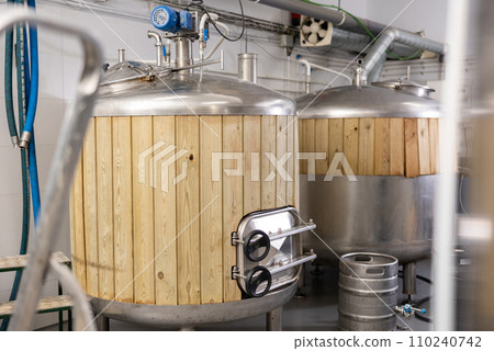 Interior of small brewery with tanks for beer fermentation and kegs Interior of small brewery with tanks for beer fermentation and kegs 110240742