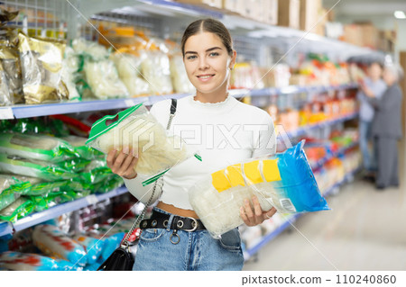 Young woman in supermarket buys daily groceries, pasta Chinese noodles 110240860