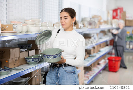 Young girl choosing ceramic soup tureen in Asian store Young girl choosing ceramic soup tureen in Asian store 110240861