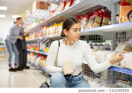 Young woman in supermarket buys daily groceries, pasta Chinese noodles 110240939