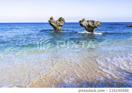 A heart rock floating in the blue sky and sea, Tinu Beach, Nakijin Village, Okinawa Prefecture 110240986