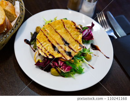 Scallop baked with cheese in seashells, served with lettuce 110241168