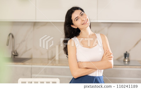 Young positive woman posing in kitchen at home Young positive woman posing in kitchen at home 110241189